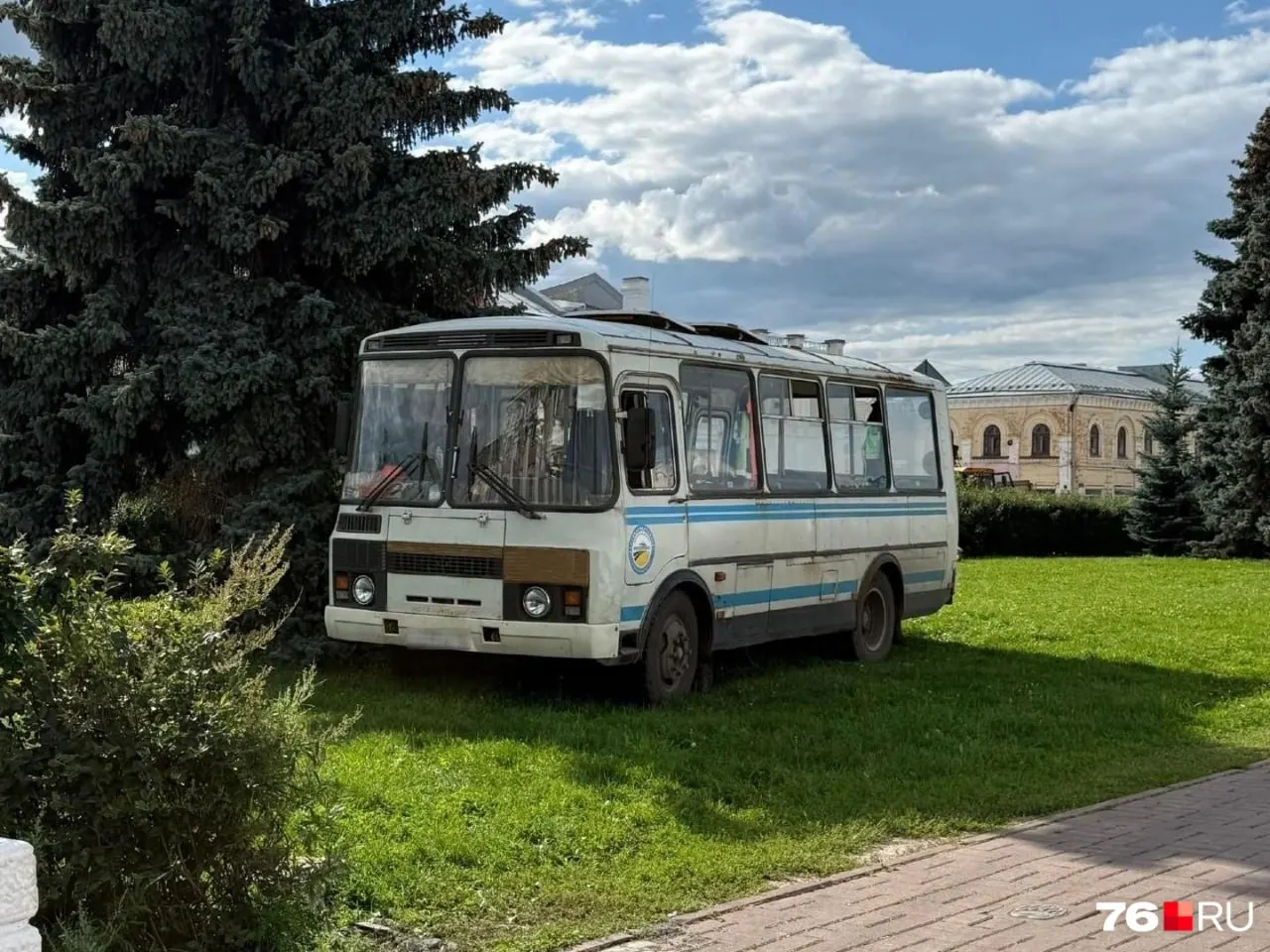 Горожане недоумевают из-за парковки автобуса на газоне напротив здания мэрии; место не огорожено и вызывает вопросы.