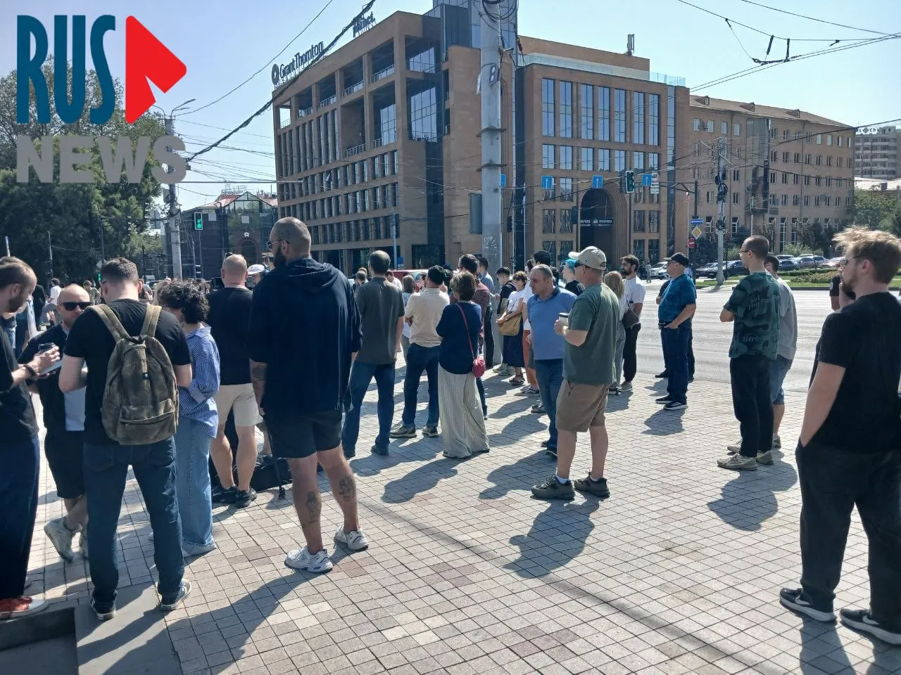 Участники голосования у посольства РФ в Ереване, включая российских туристов и активистов, ждут возможности проголосовать; рядом проходит митинг.